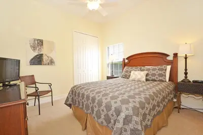 a bedroom with a bed and a flat screen tv at Lake House at Formosa home in Orlando