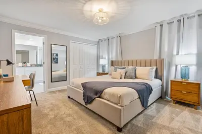 a bedroom with a bed with a chair and a desk at New Home 4 Bedrooms 3 Bathrooms At Storey Lake in Kissimmee