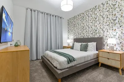a bedroom with a bed and a tv and curtains at New Home 4 Bedrooms 3 Bathrooms At Storey Lake in Kissimmee