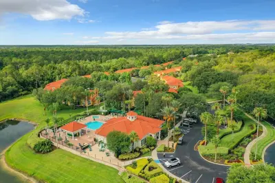 an aerial view of a resort with a pool and trees at Near Disney + FREE Clubhouse + Pool + GYM + Sauna in Kissimmee
