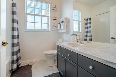 a bathroom with a sink and a toilet and a window at Windsor Palms Gem: Stylish and Fully Equipped in Kissimmee