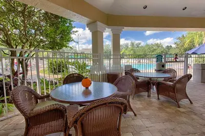 a patio with tables and chairs and a pool at Windsor Palms Gem: Stylish and Fully Equipped in Kissimmee