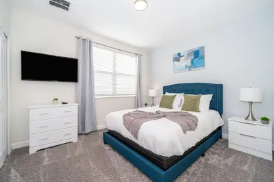 a bedroom with a blue bed and a tv at 800MO VILLA 5 BED/5 BA in Orlando
