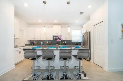 a kitchen with a large island with bar stools at 3000EB VILLA 5 BED/5 BA in Kissimmee