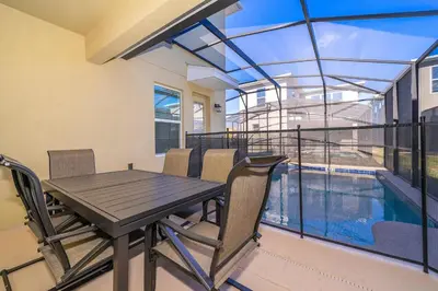 a dining room with a table and chairs and a pool at 3000EB VILLA 5 BED/5 BA in Kissimmee