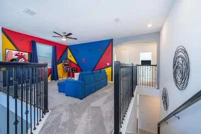 a living room with a mural on the wall at 3000EB VILLA 5 BED/5 BA in Kissimmee