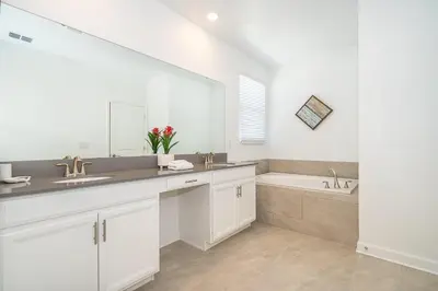 a white bathroom with a sink and a tub at 3000EB VILLA 5 BED/5 BA in Kissimmee