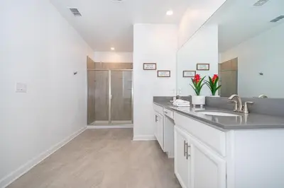 a white bathroom with a sink and a shower at 3000EB VILLA 5 BED/5 BA in Kissimmee