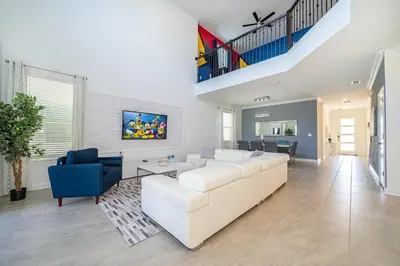 a living room with a white couch and a blue chair at 3000EB VILLA 5 BED/5 BA in Kissimmee