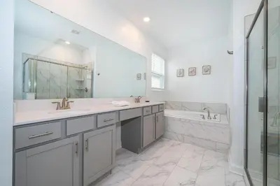 a white bathroom with two sinks and a tub at 4176SS STOREY LAKE VILLA WITH PRIVATE POOL in Kissimmee