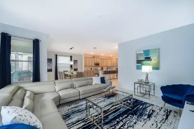 a living room with a white couch and a blue chair at 4176SS STOREY LAKE VILLA WITH PRIVATE POOL in Kissimmee