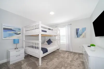 a white bedroom with a bunk bed and a desk at 4188FA TOWNHOUSE 4 BEDROOMS & 3 BATHROOMS + POOL in Kissimmee