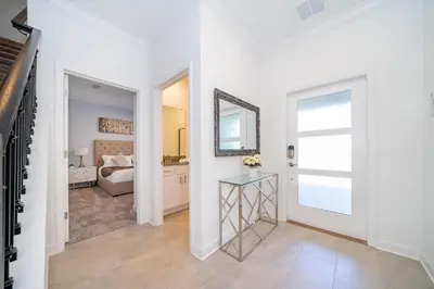 a white hallway with a table and a bedroom at 4188FA TOWNHOUSE 4 BEDROOMS & 3 BATHROOMS + POOL in Kissimmee