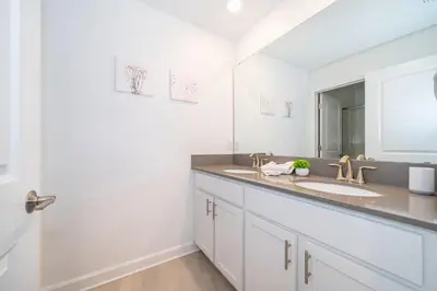 a bathroom with two sinks and a mirror at 4188FA TOWNHOUSE 4 BEDROOMS & 3 BATHROOMS + POOL in Kissimmee