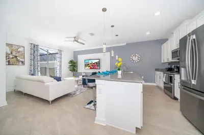 a kitchen and living room with a couch and a refrigerator at 4188FA TOWNHOUSE 4 BEDROOMS & 3 BATHROOMS + POOL in Kissimmee