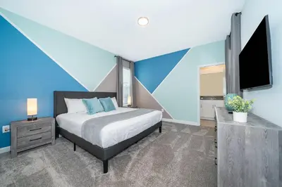a bedroom with a bed and a flat screen tv at 4338JC VILLA 5 BED/5 BA (SANITIZED) in Kissimmee