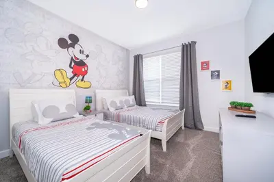 a bedroom with two beds and a mickey mouse mural at 2668DR VILLA 5 BED/5 BA (SANITIZED) in Kissimmee