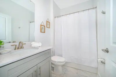 a white bathroom with a sink and a toilet at 2668DR VILLA 5 BED/5 BA (SANITIZED) in Kissimmee