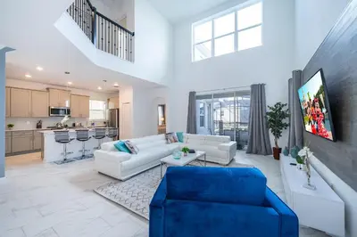 a living room with white furniture and a blue couch at 2668DR VILLA 5 BED/5 BA (SANITIZED) in Kissimmee