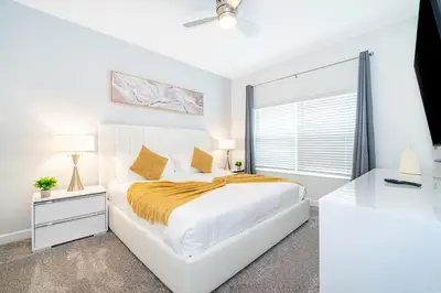 a white bedroom with a large bed and a window at 2472PB TOWNHOUSE 4 BEDROOMS & 3 BATHROOMS + POOL in Kissimmee