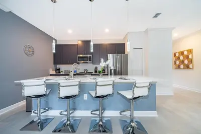 a kitchen with a large island with bar stools at 2472PB TOWNHOUSE 4 BEDROOMS & 3 BATHROOMS + POOL in Kissimmee