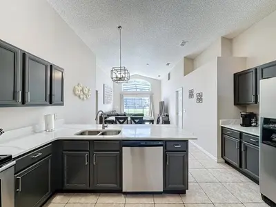 a kitchen with black cabinets and a sink at 5 Star Home Private Pool & JaccuzziFree Wi-Fi villa in Kissimmee