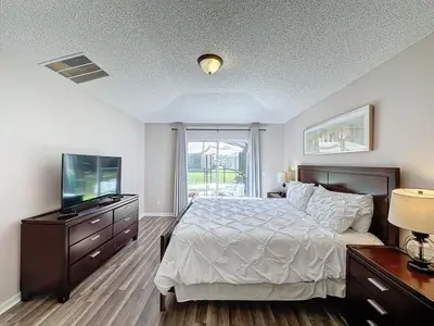 a bedroom with a bed and a flat screen tv at 5 Star Home Private Pool & JaccuzziFree Wi-Fi villa in Kissimmee