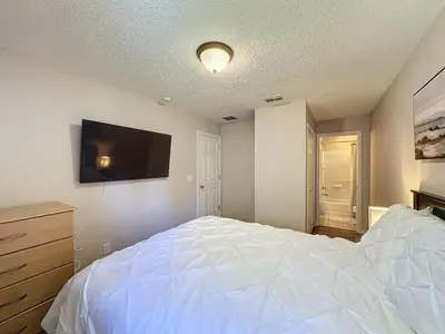 a bedroom with a white bed and a flat screen tv at 5 Star Home Private Pool & JaccuzziFree Wi-Fi villa in Kissimmee