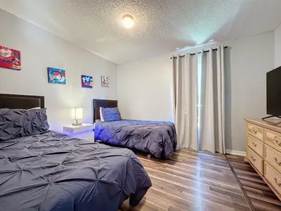 a bedroom with two beds and a flat screen tv at 5 Star Home Private Pool & JaccuzziFree Wi-Fi villa in Kissimmee