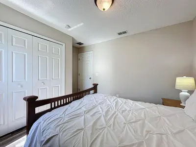 a bedroom with a large white bed with a door at 5 Star Home Private Pool & JaccuzziFree Wi-Fi villa in Kissimmee