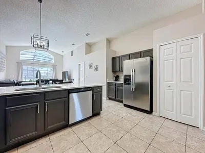 a kitchen with a stainless steel refrigerator and a sink at 5 Star Home Private Pool & JaccuzziFree Wi-Fi villa in Kissimmee