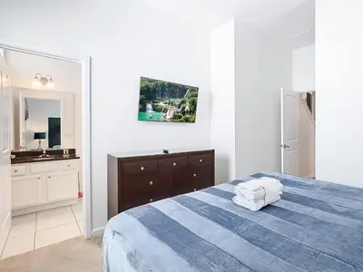 a white bedroom with a blue bed and a sink at Elegant Villa 12BD-12BA Vacation Haven BV368 in Kissimmee