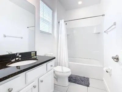 a white bathroom with a sink and a toilet at Elegant Villa 12BD-12BA Vacation Haven BV368 in Kissimmee