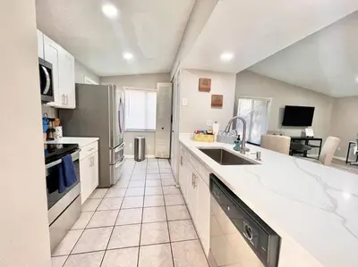 a large kitchen with white counter tops and appliances at Quiet home in Metrowest in Orlando