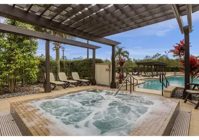 a hot tub on a patio next to a swimming pool at Sunny Summer Awaits - Renovated Townhome by Disney! in Orlando