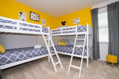 two bunk beds in a room with yellow walls at Gorgeous Family Home! Sleeps 28 BLV103 in Kissimmee