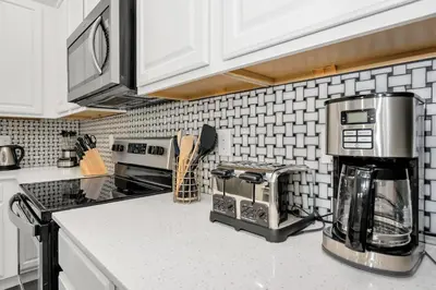 a kitchen with white cabinets and a counter top at Vacation Paradise Home, Private Pool, Game Room BL102 in Kissimmee