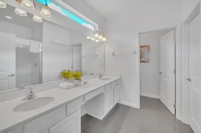 a white bathroom with two sinks and a large mirror at Vacation Paradise Home, Private Pool, Game Room BL102 in Kissimmee