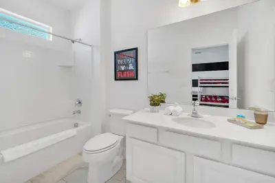 a white bathroom with a toilet and a sink at Vacation Paradise Home, Private Pool, Game Room BL102 in Kissimmee