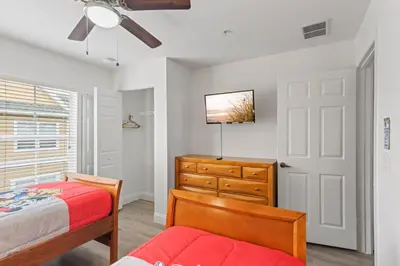 a bedroom with a bed and a dresser and a ceiling fan at The Villas at Seven Dwarfs - 4564 Luxury Villa - Near Disney - Water Park in Kissimmee