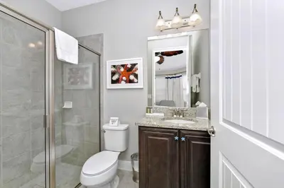 a bathroom with a toilet and a sink and a shower at Astounding Home Near Disney With Themed & Media Room, Pool Table With Waterpark & Resort Access At Encore Resorts Reunion - 240Cl in Kissimmee