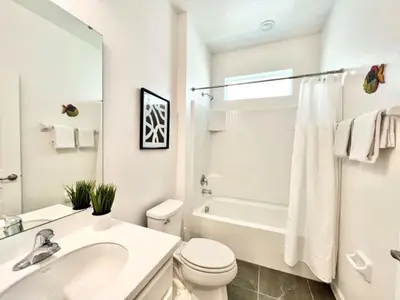 a white bathroom with a sink toilet and a tub at BV310MB - Disney & Universal heroes - 16 guests in Kissimmee