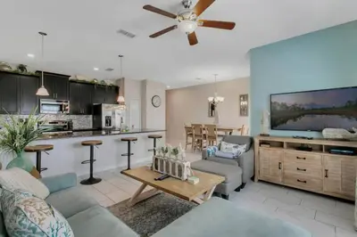 a living room with a ceiling fan and a kitchen at StoreyLake Disney Pool Home, Lake View, By Disney in Kissimmee