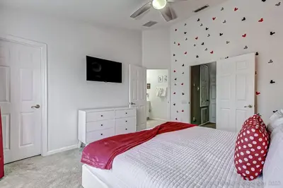 a bedroom with a white bed with a red blanket at SilverPalm Disney Home, Free Amenities, 3mi Disney in Kissimmee