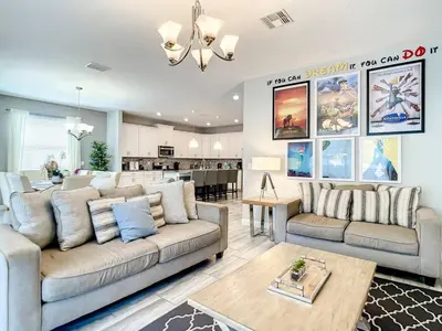 a living room with two couches and a kitchen at StoreyLake Imagination Villa, 5mi Disney Universal in Kissimmee