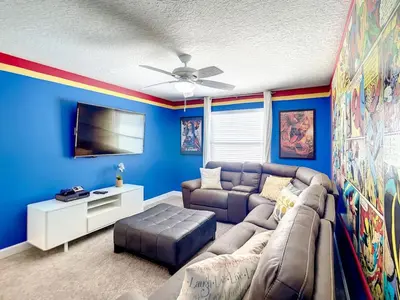 a living room with a couch and a flat screen tv at StoreyLake Imagination Villa, 5mi Disney Universal in Kissimmee