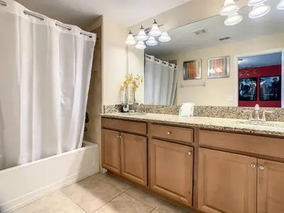 a bathroom with two sinks and a shower and a tub at Storey Lake Dreamy Townhome, 5 mi Disney Universal in Kissimmee