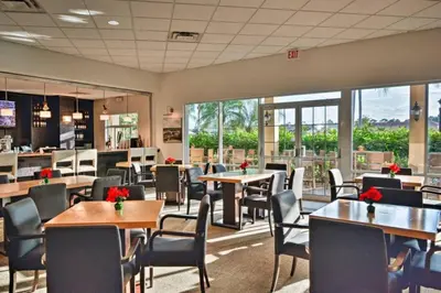 a restaurant with tables and chairs and windows at Enchanted Jungle Themed Home Pool 3mi to Disney in Kissimmee