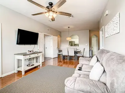 a living room with a couch and a flat screen tv at Windsor Hills Mickey Mouse Condo, 2.5mi Disney in Orlando