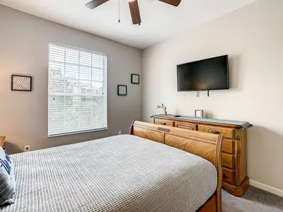 a bedroom with a bed and a flat screen tv at Windsor Hills Mickey Mouse Condo, 2.5mi Disney in Orlando